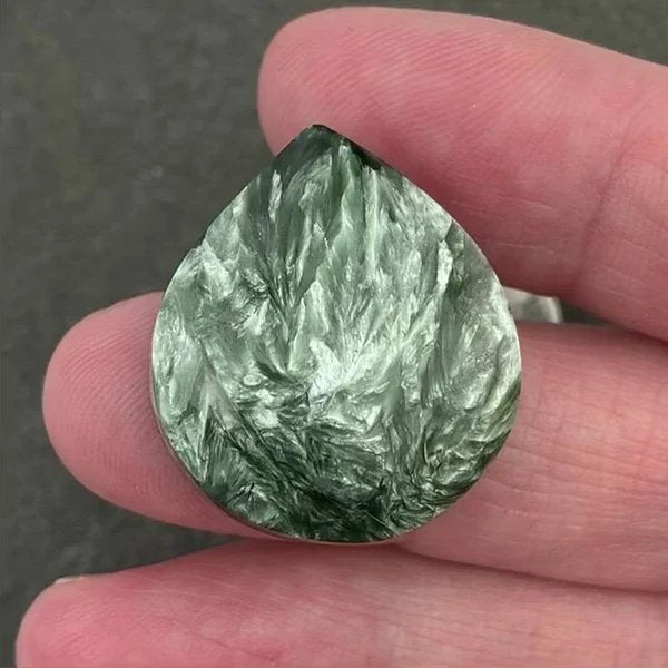 Seraphinite cabochon — deep green with silvery feathered chatoyance