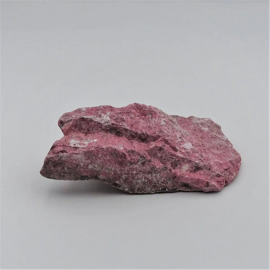Raw thulite — raspberry pink mottled with white and grey